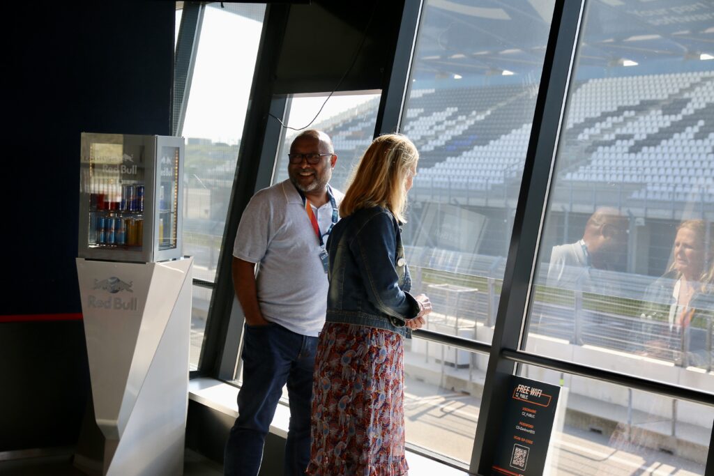 gasten van een rondleiding kijken naar de start finish op circuit Zandvoort in de redbull lounge