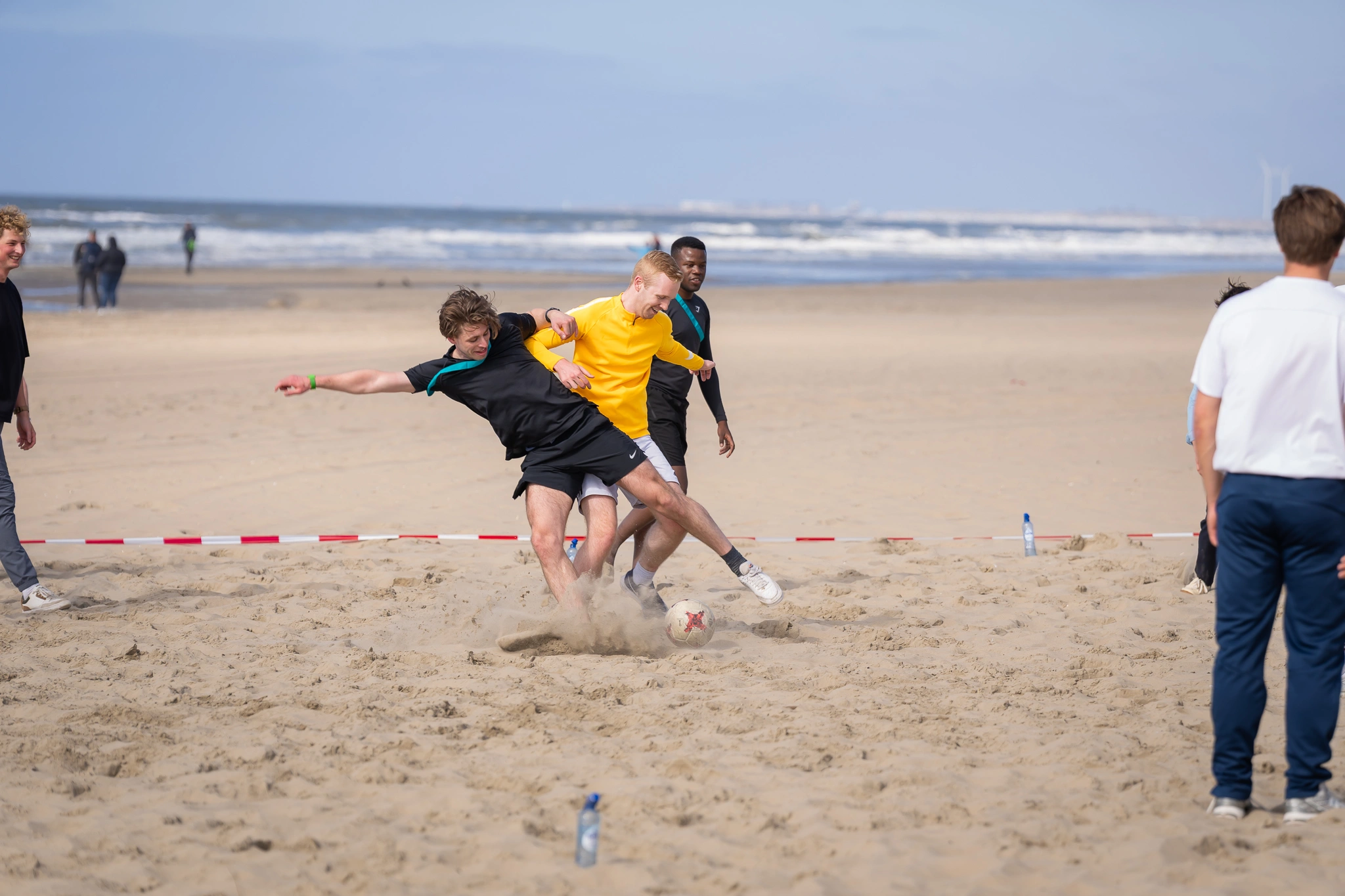 Outdoor Teambuilding gasten van het ey evenement tijdens een teambuilding activiteit op het strand